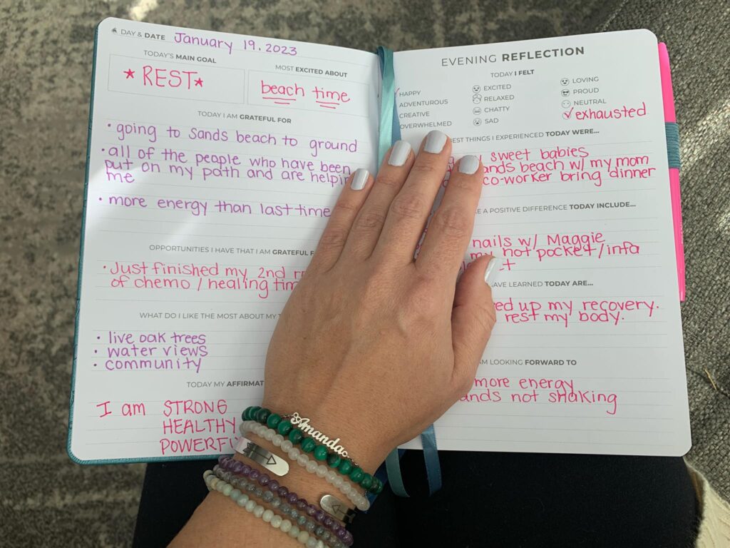 Female hand resting on an opened gratitude journal