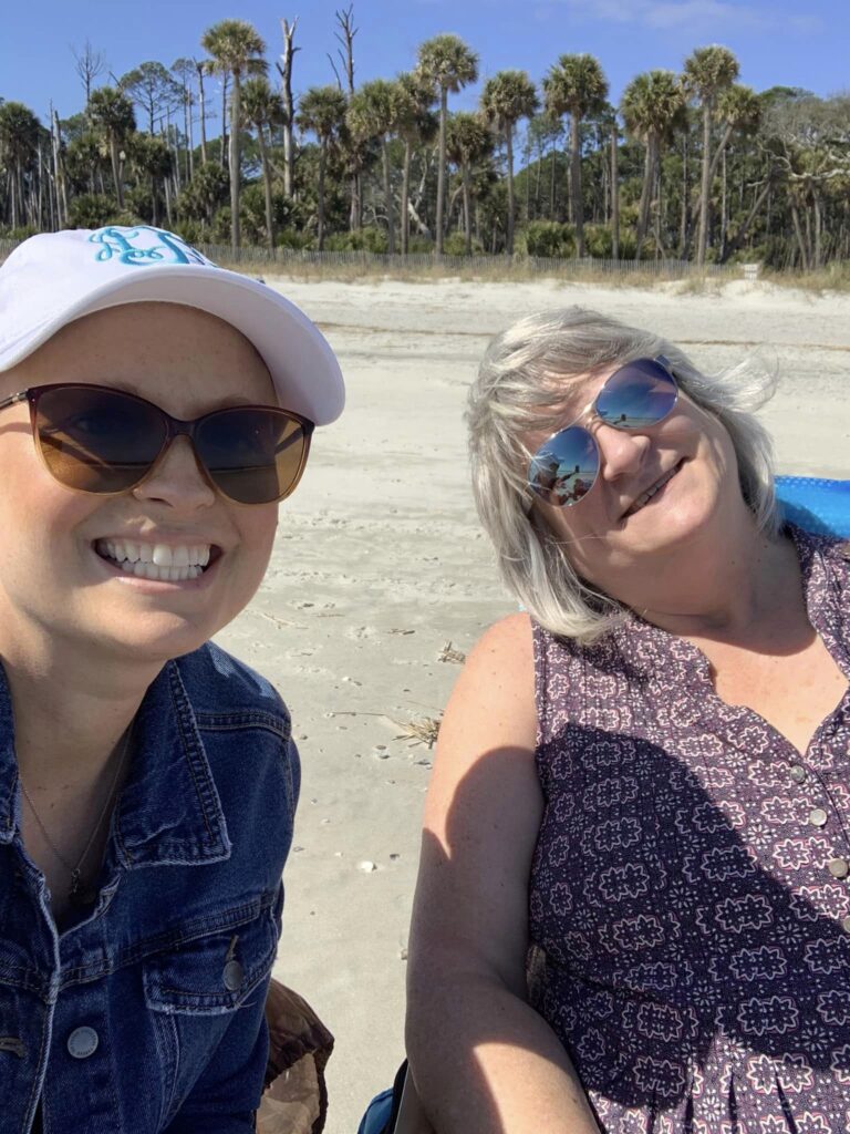 Mother and daughter pose for picture by ocean