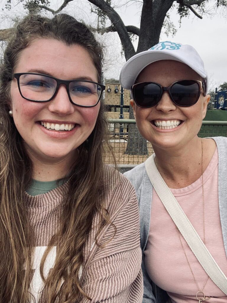 two girls smiling for camera on bench