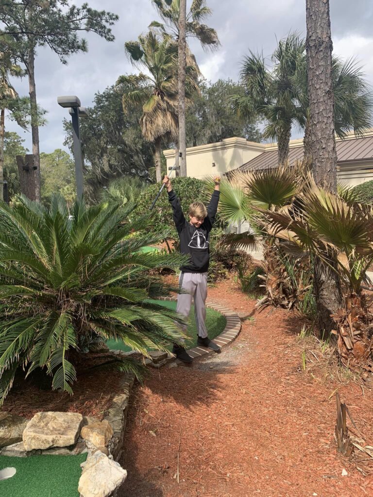 boy celebrating golf putt