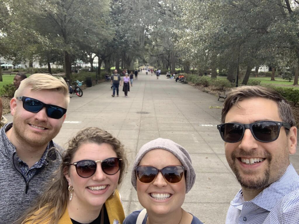 Two couples smiling for picture in park