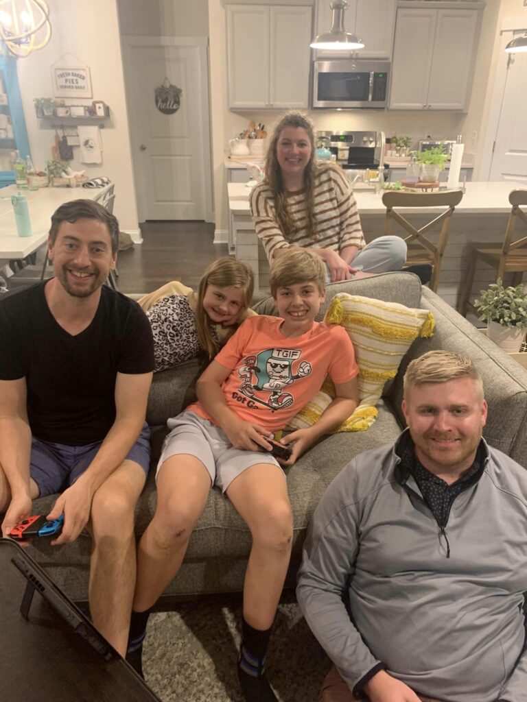 group of people smiling for picture in a family room
