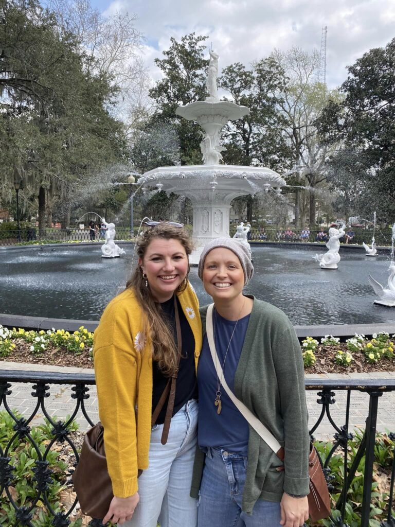 Two women posing in front of a fountain