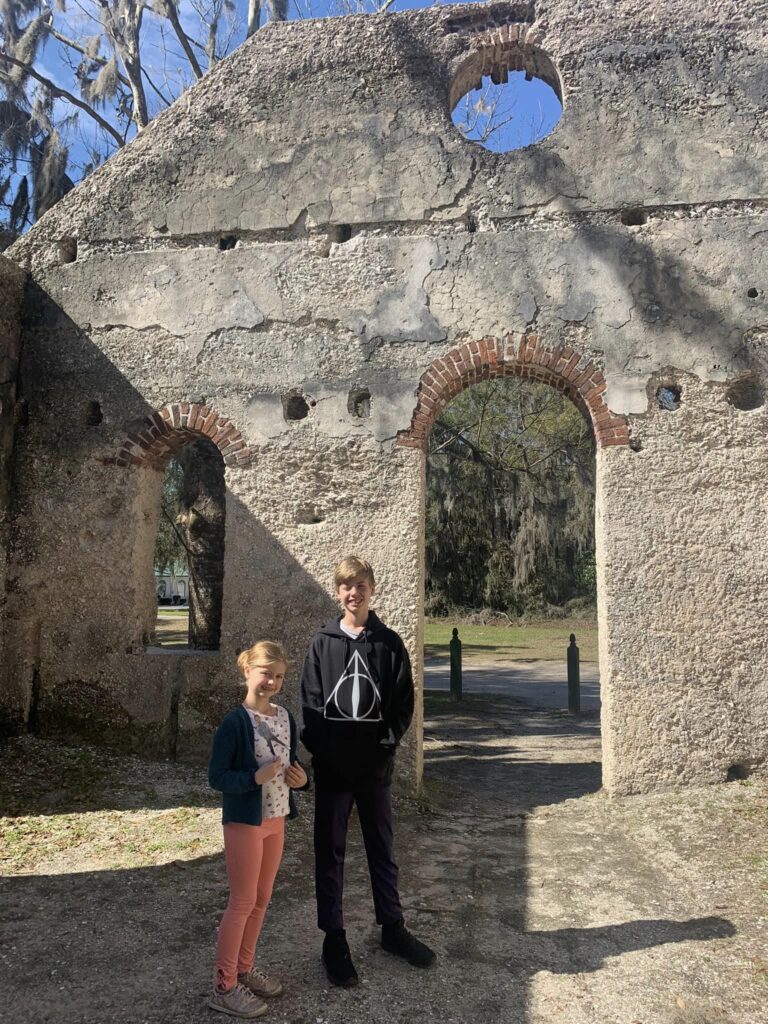 kids posing for a picture with an old church ruins behind them
