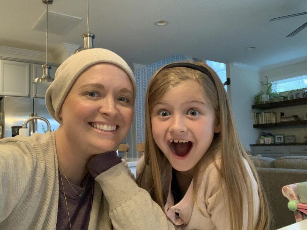 Mother smiling while daughter has big open smile