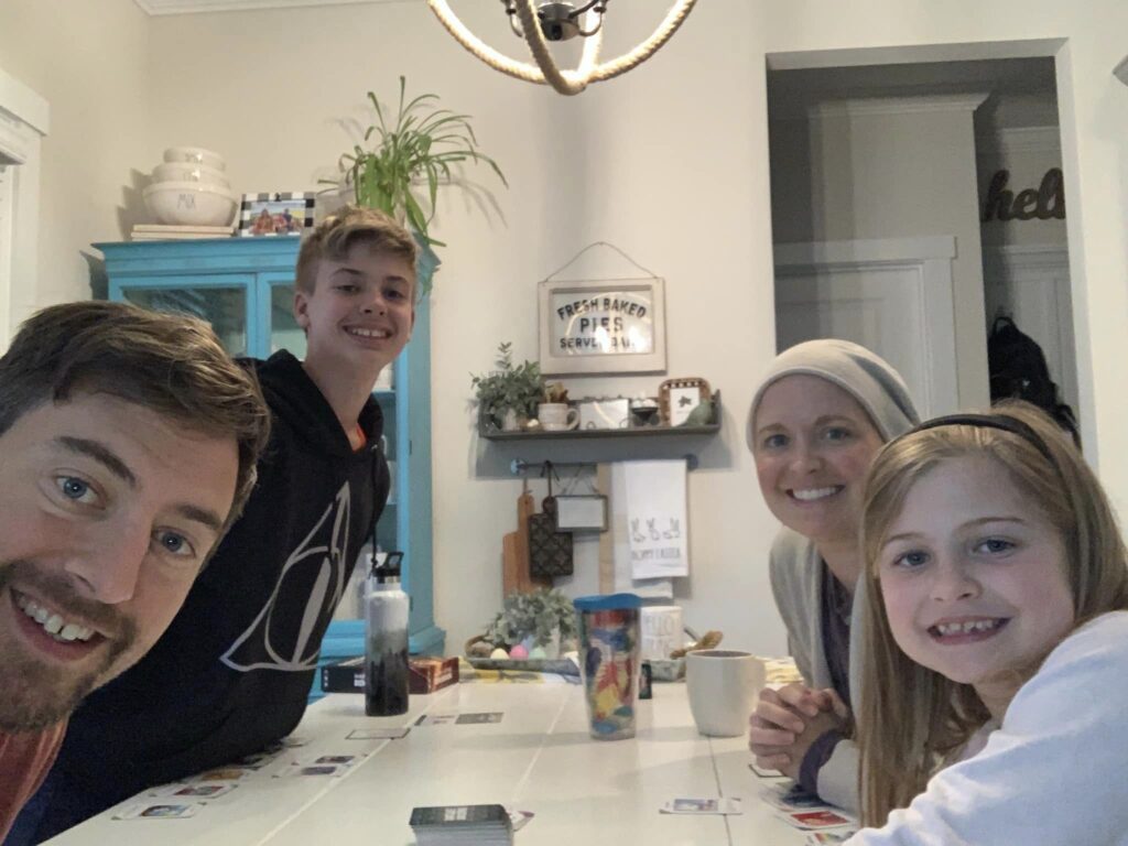 Mother and son smiling at kitchen table playing card game